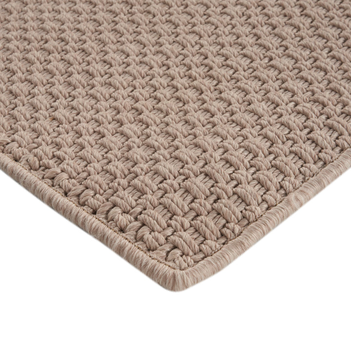 Close-up of plush, thick beige carpet with bound finish