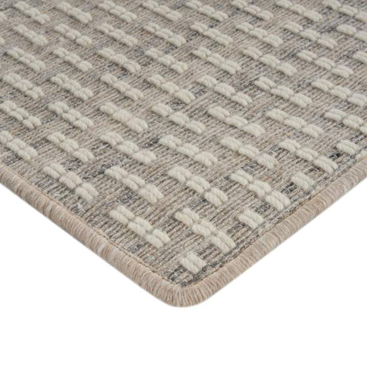 Close-up of durable woven rug with textured beige pattern design.
