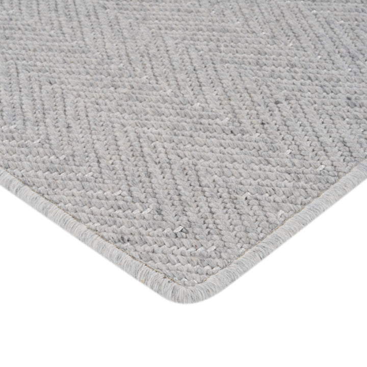 Gray textured rug with raised lines and geometric design pattern
