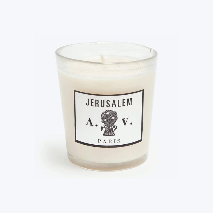 White scented candle in chic Jerusalem-themed glass container, unlit wick.