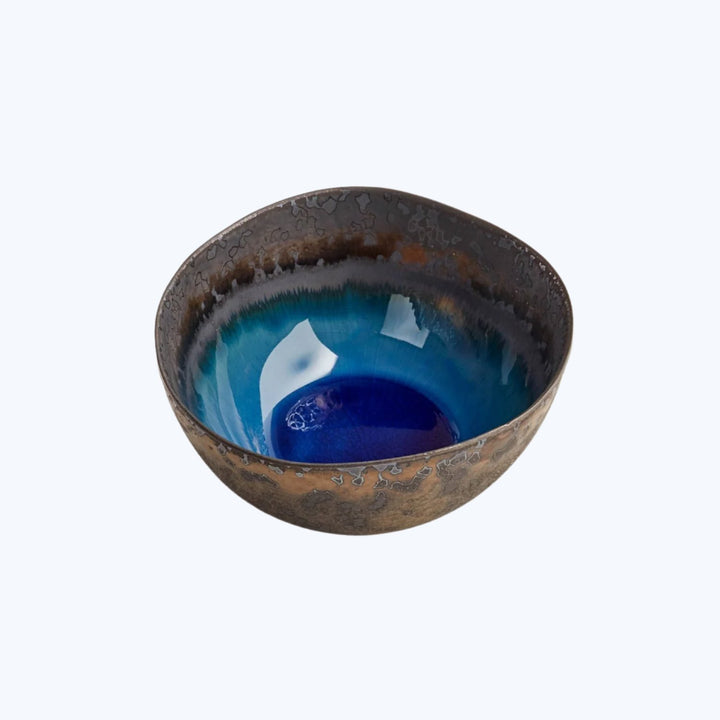 Artisanal ceramic bowl with textured exterior and gradient blue interior.