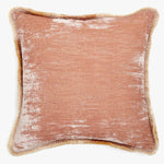 A vintage-style pink cushion with a golden-brown fringe detail.