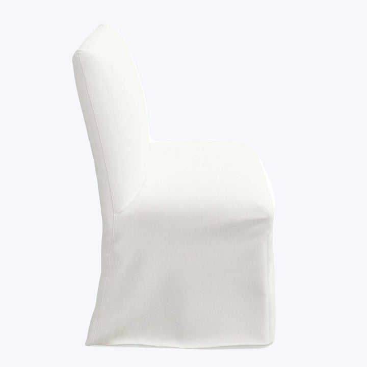 White slipcover snugly fits over chair, concealing original upholstery details.