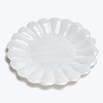 Elegant white ceramic plate with scalloped edges and decorative border.