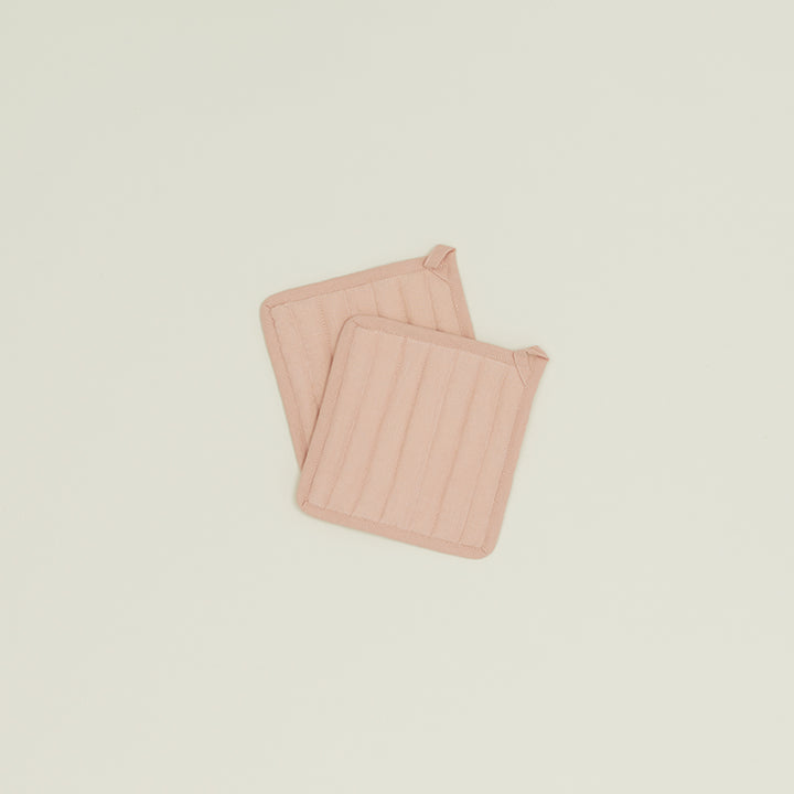 Quilted pink pot holders with fabric loops for hanging.