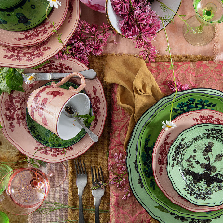 Vintage table setting with whimsical plates, flowers, and silverware.